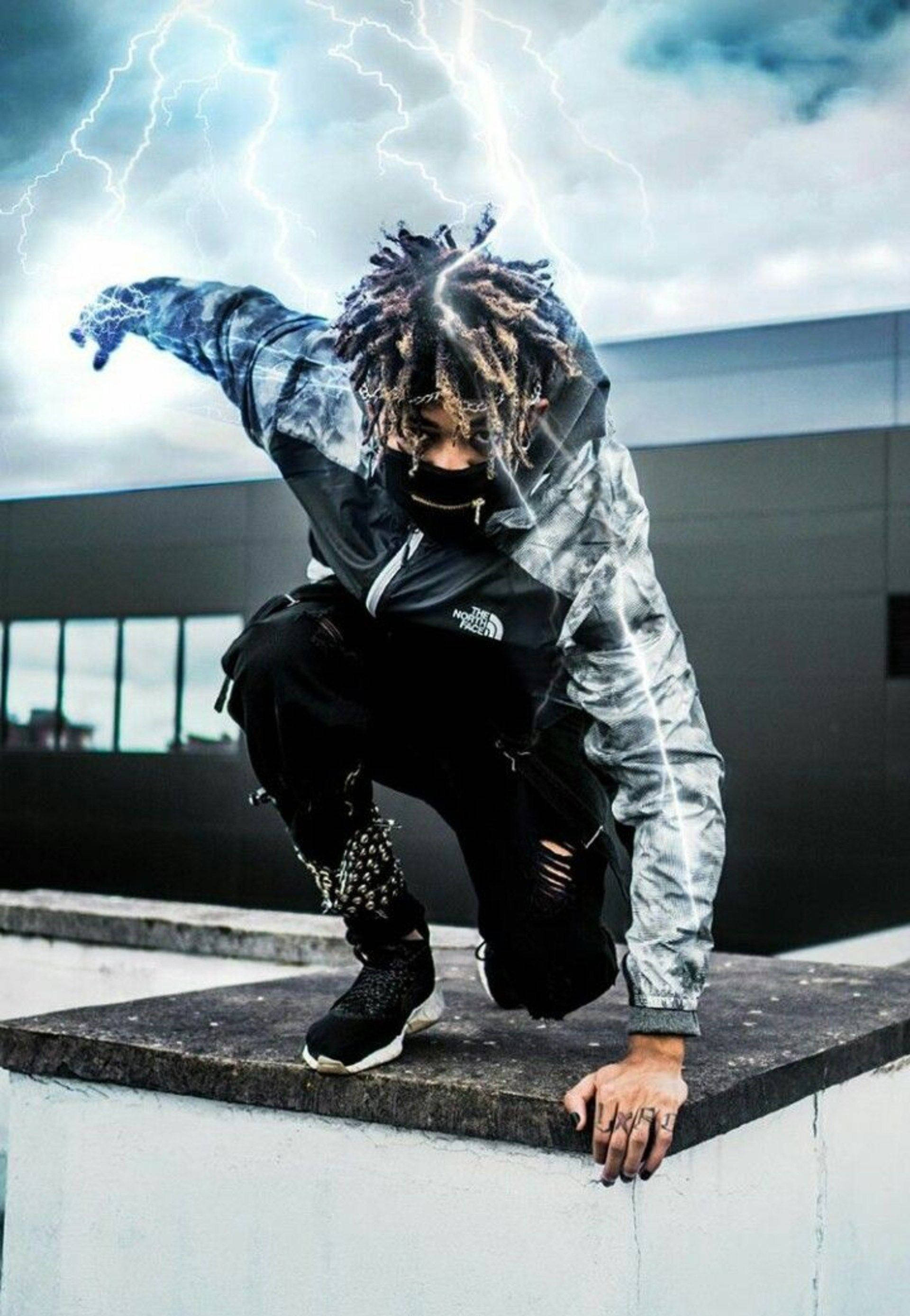 Scarlxrd 落地姿勢 壁紙 — 一個留著辮子的人蹲在屋頂上，背後閃電劃破暴風雨的天空。