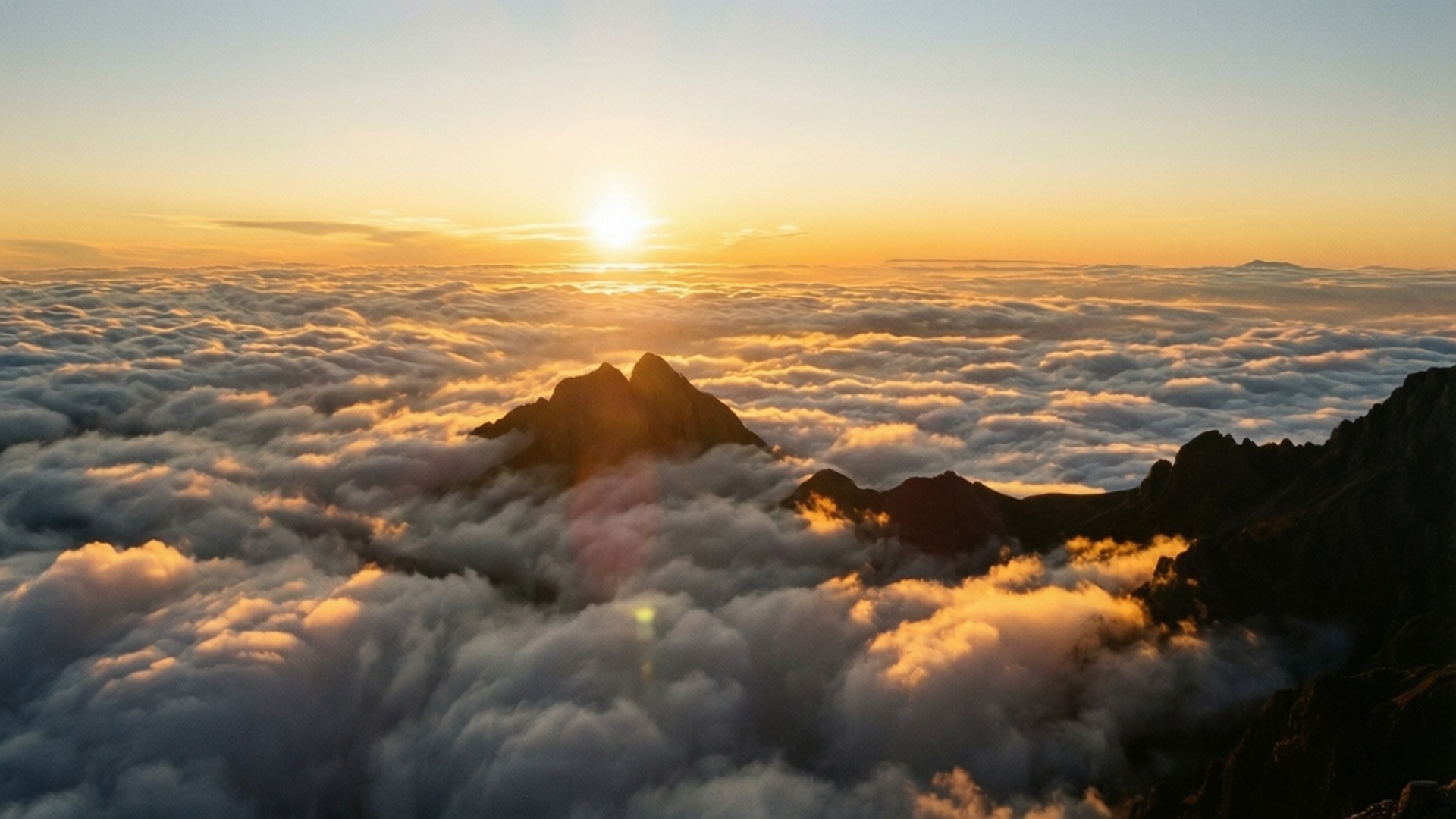 日出於雲海之上聳立的山峰