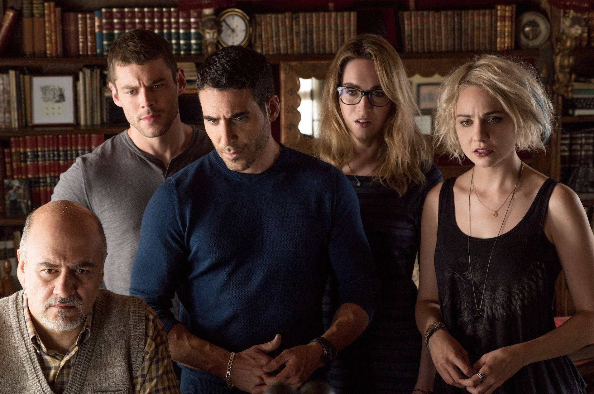 《Sense8》劇組群像 壁紙 — 五個緊張嘅人企喺一個燈光昏暗、充滿書架嘅圖書館入面，佢哋嘅表情傳達出懷疑同不安。