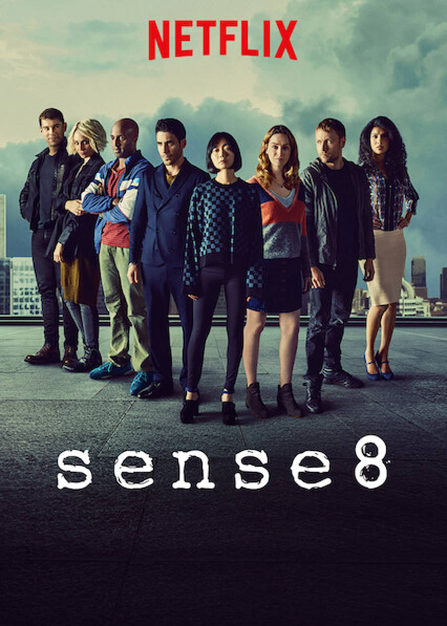 《Sense8》Netflix 宣傳海報 壁紙 — 八個不同的角色自信地站在屋頂上，背景是陰雲密佈的城市天際線，帶有 Netflix 和 Sense8 標誌。
