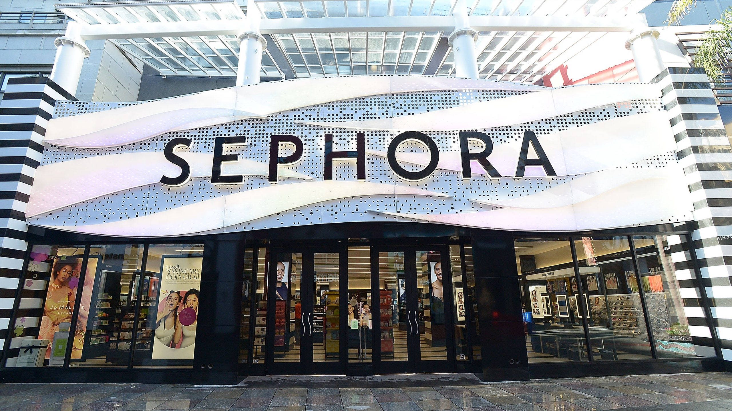 Sephora 商店分店 壁紙 — 現代Sephora店舖外牆，採用大膽的黑白條紋柱和玻璃簷篷下的弧形招牌。