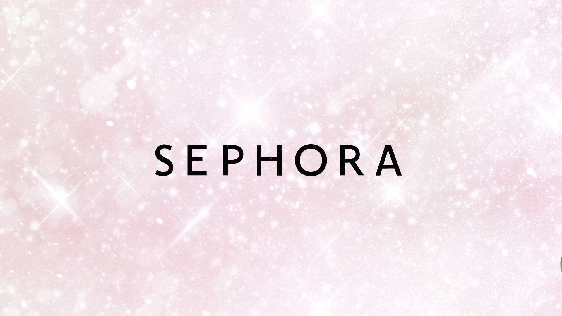 Sephora 粉紅閃耀風 壁紙 — 「Sephora」一詞以粗體黑色字樣，在閃爍著白色星星的柔和粉紅色背景上突出顯示。