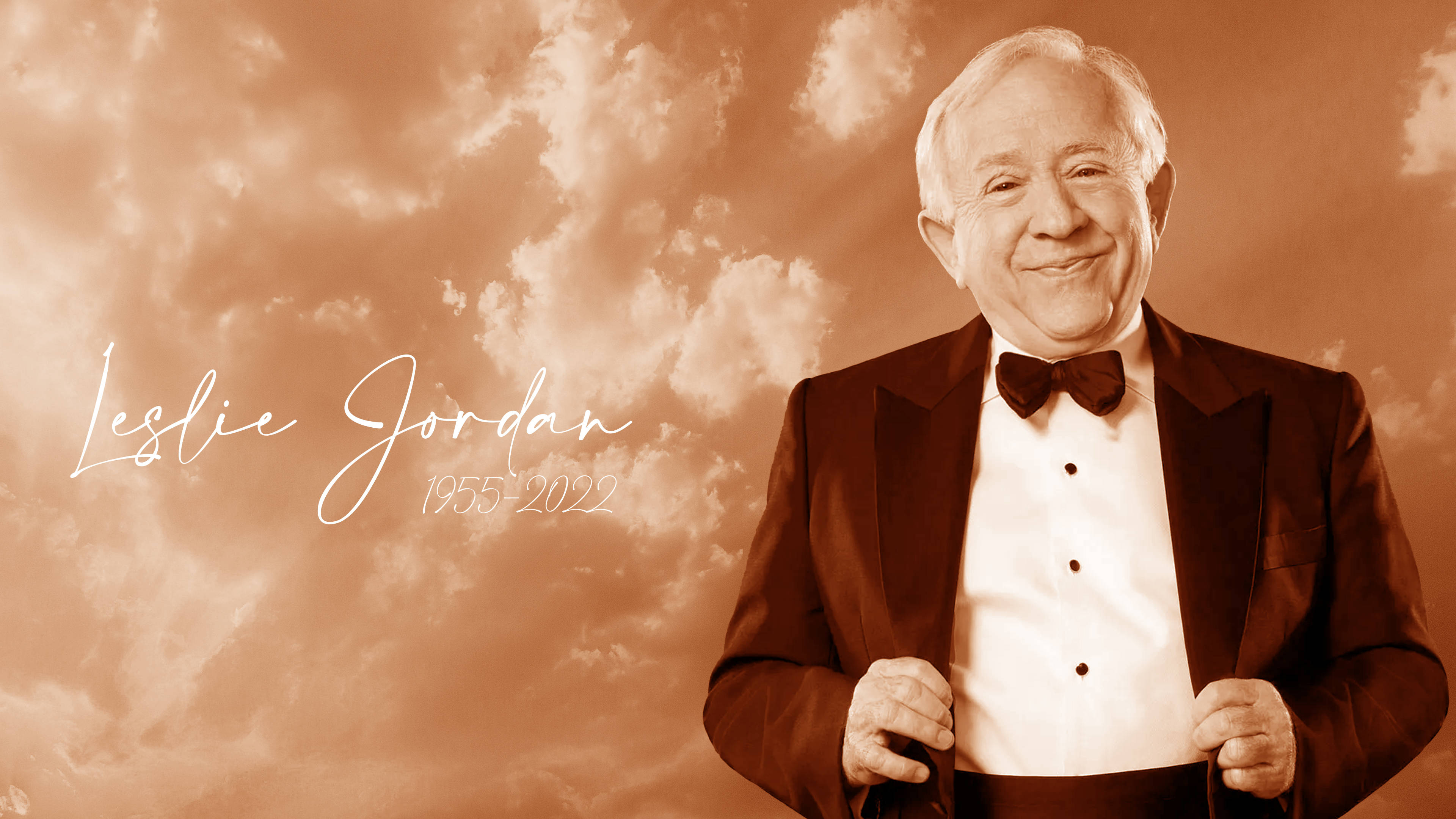 萊斯利·喬丹紀念 Sepia 背景 壁紙 — Leslie Jordan 身穿燕尾服，在泛黃的陰雲天空背景下溫暖微笑，他的名字和年份以優雅的字體顯示。