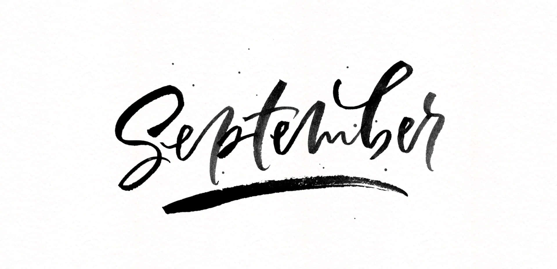 九月 桌布 壁紙 — 「September」一詞以粗體黑色毛筆書法書寫，並在帶有紋理的白色紙張上加上流暢的底線。