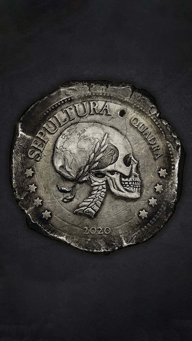 Sepultura Quadra 硬幣 壁紙 — 一枚風化的銀幣，上面有一個頭部為地球的骷髏，以及文字 Sepultura Quadra 2020，背景為深色紋理。