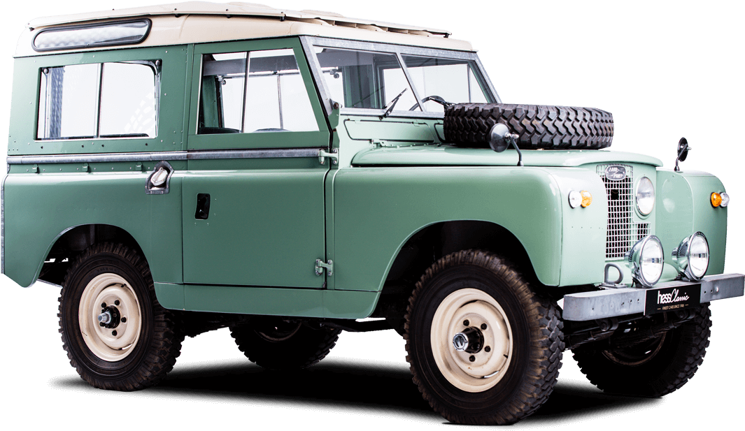 經典綠色路虎Series I 壁紙 — 一輛復古綠色 Land Rover Series IIA，帶有奶油色點綴和安裝在引擎蓋上的備用輪胎，孤立在黑色背景前。