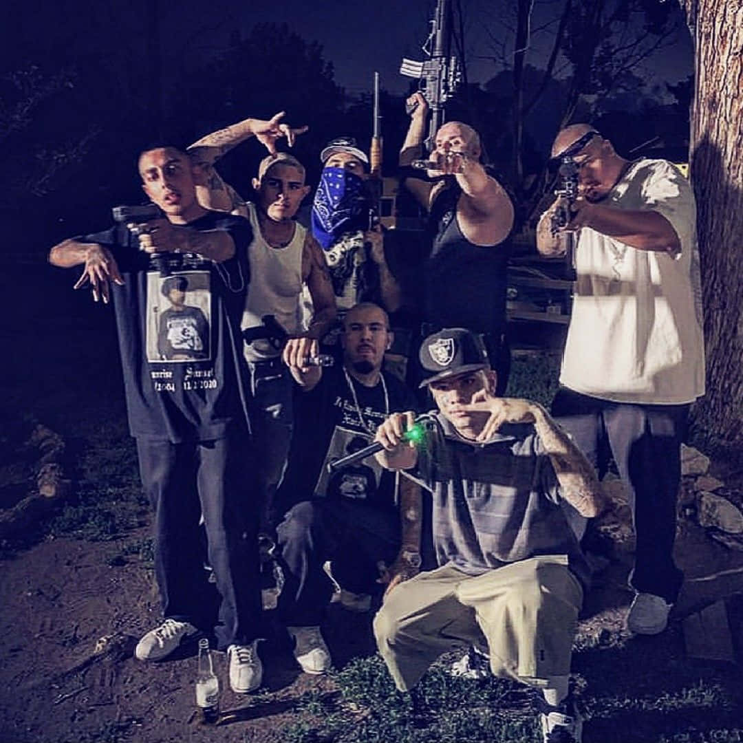  壁紙 — 七名男子在夜間人造燈光下的陰暗樹林地區手持槍械擺姿勢。