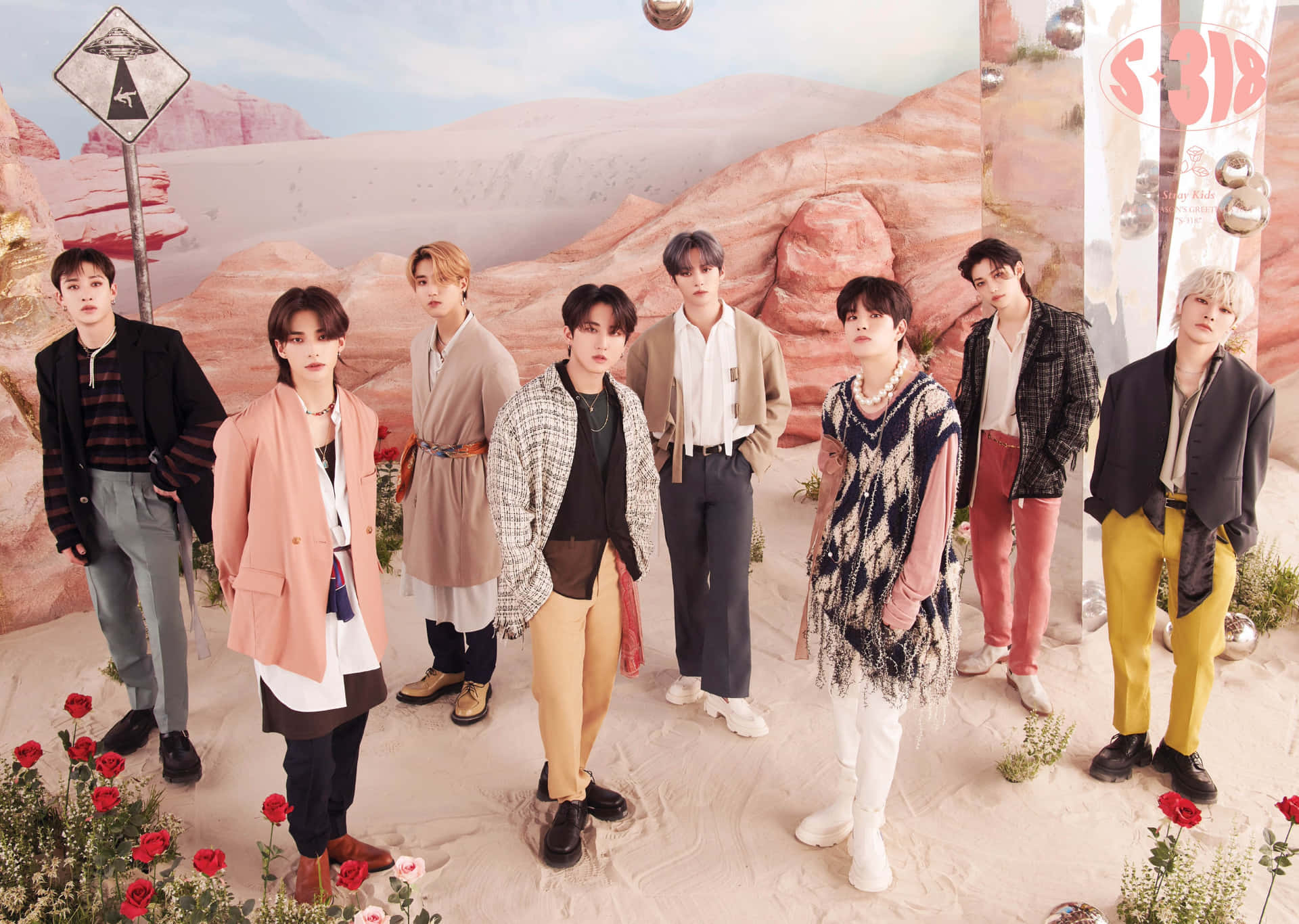 七位時尚男子在沙漠中擺姿勢，背景有粉紅色岩石和紅玫瑰。 — Stray kids GIF 壁紙