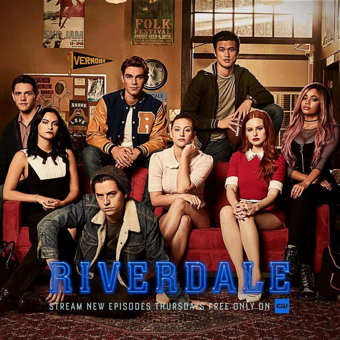 七名《Riverdale》青少年在裝飾有節目標題的房間裡的紅色沙發上擺姿勢。