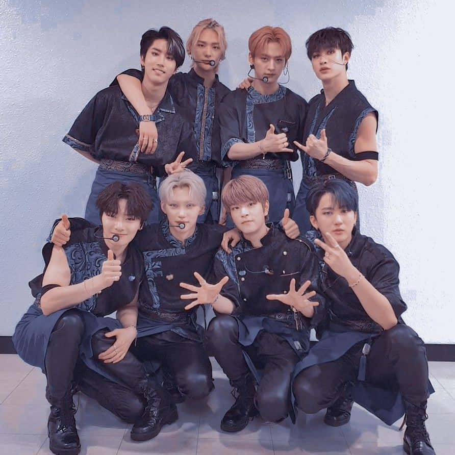 七位身穿相配深藍色服裝的K-pop偶像，擺出各種手勢姿勢。 — Stray kids GIF 壁紙