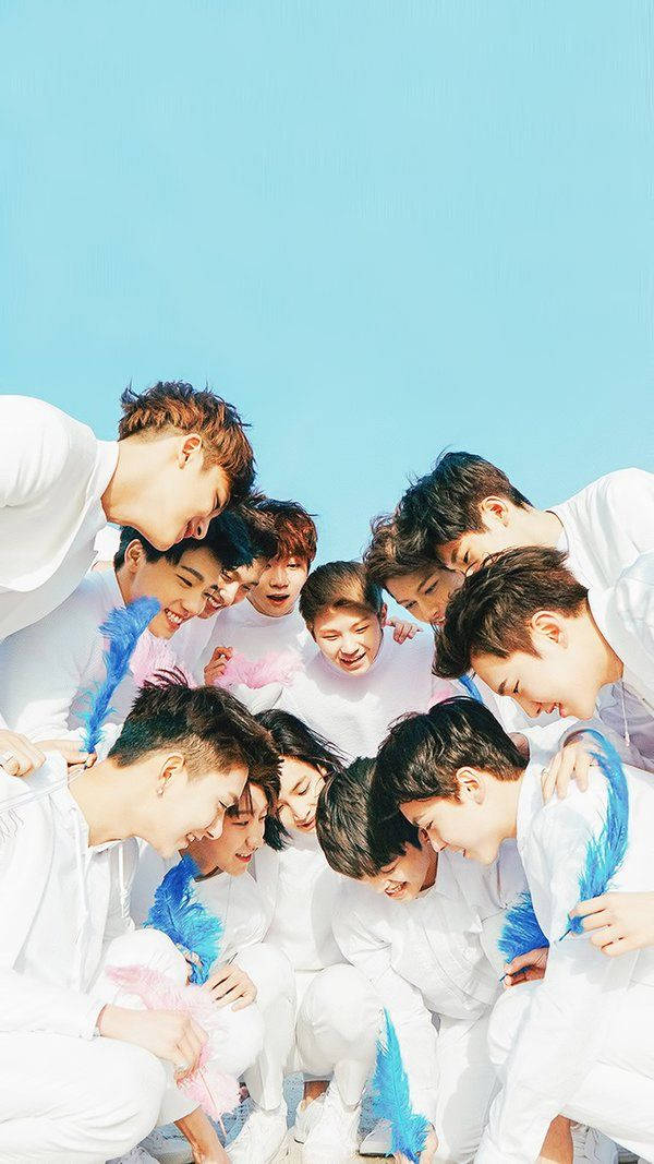 SEVENTEEN《Love & Letter》專輯封面壁紙 壁紙 — 一群身穿白色服裝的年輕男子在明亮的藍天下聚在一起大笑。