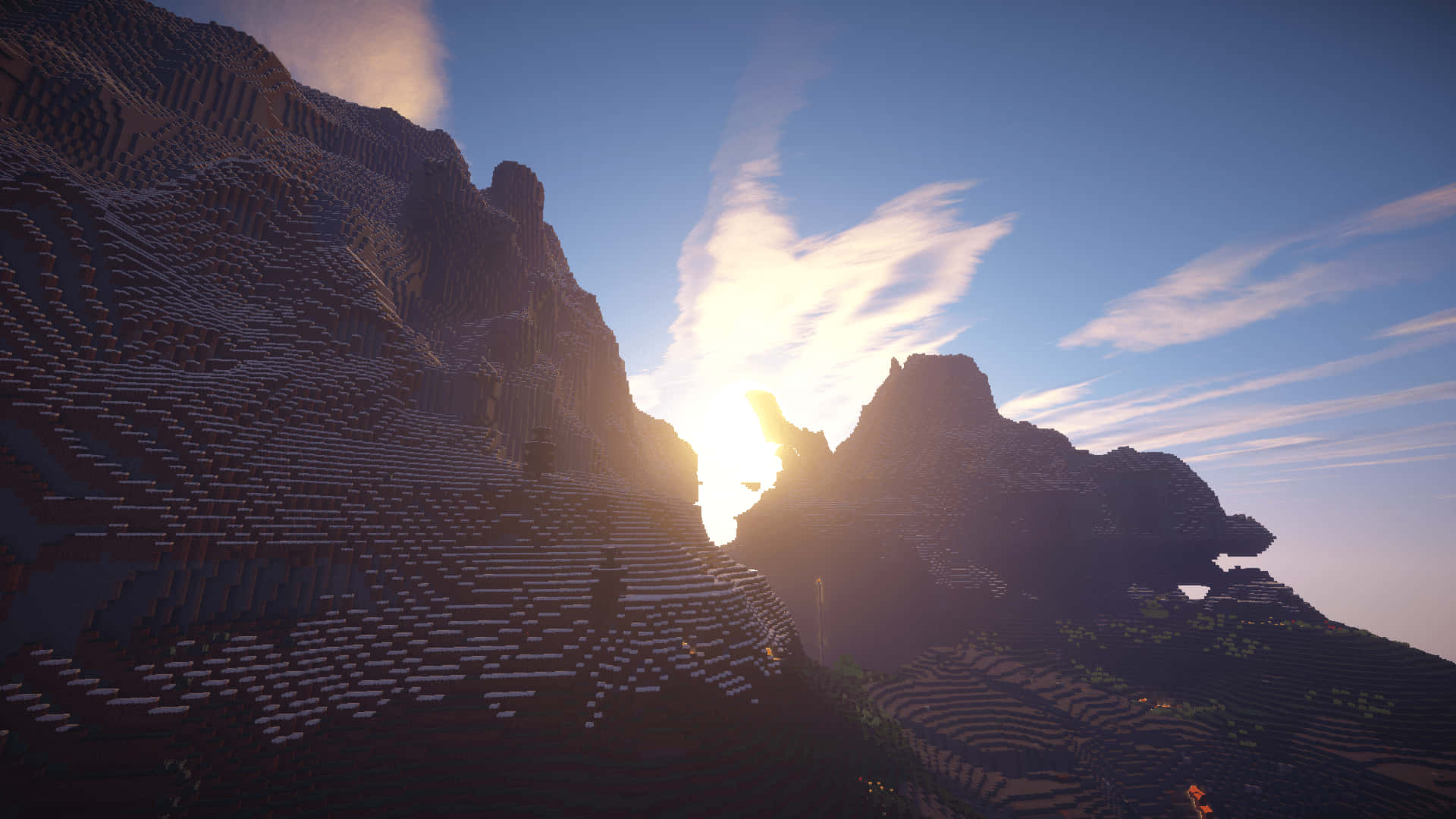 使用 Shader 探索 Minecraft 的全新視覺世界 壁紙 — 夕陽在像素化Minecraft景觀中的塊狀山峰之間發光，伴隨著縷縷雲彩。