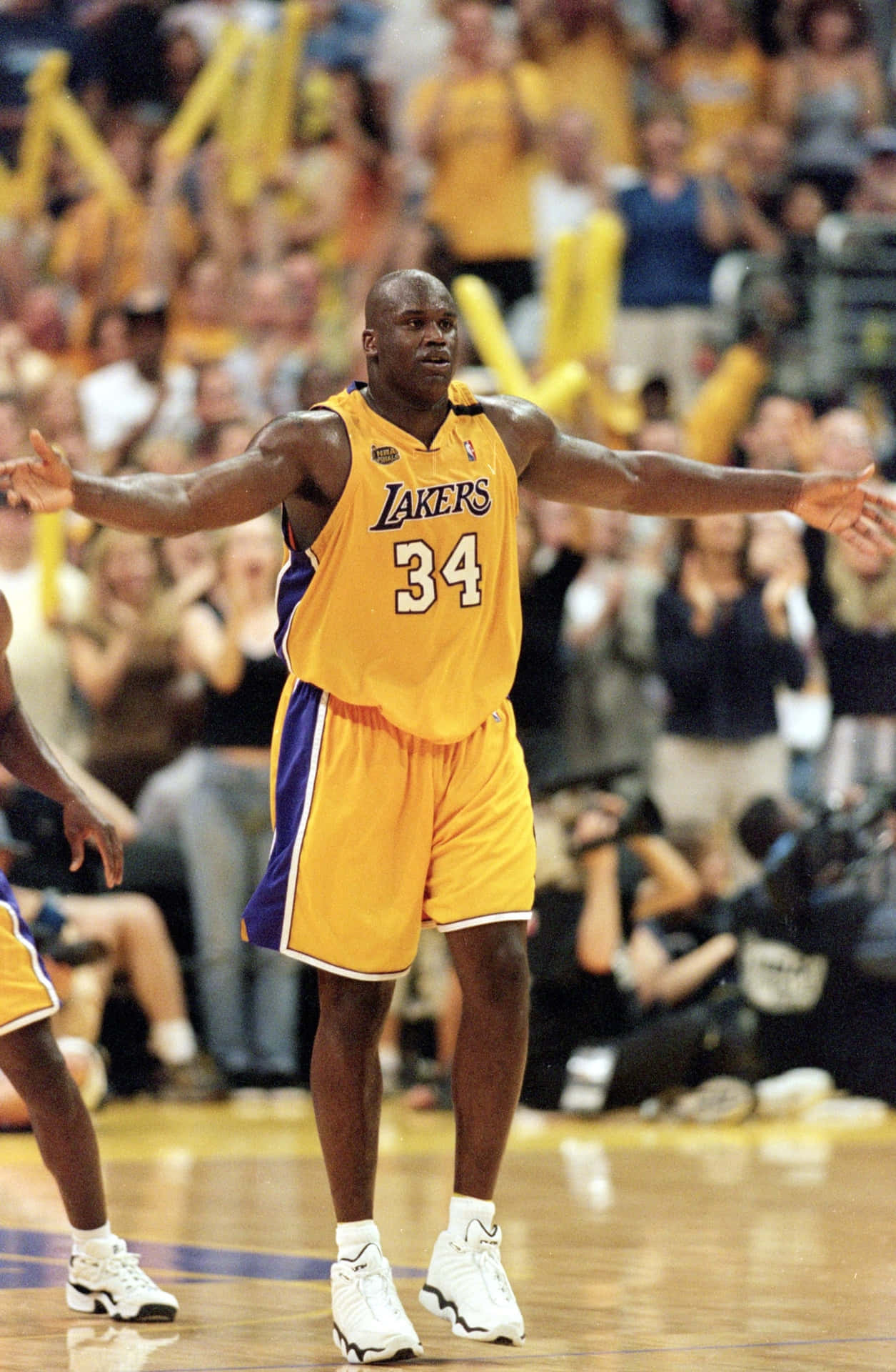  壁紙 — Shaquille O'Neal 身穿湖人隊34號球衣，在籃球場上張開雙臂，身後有歡呼的群眾。