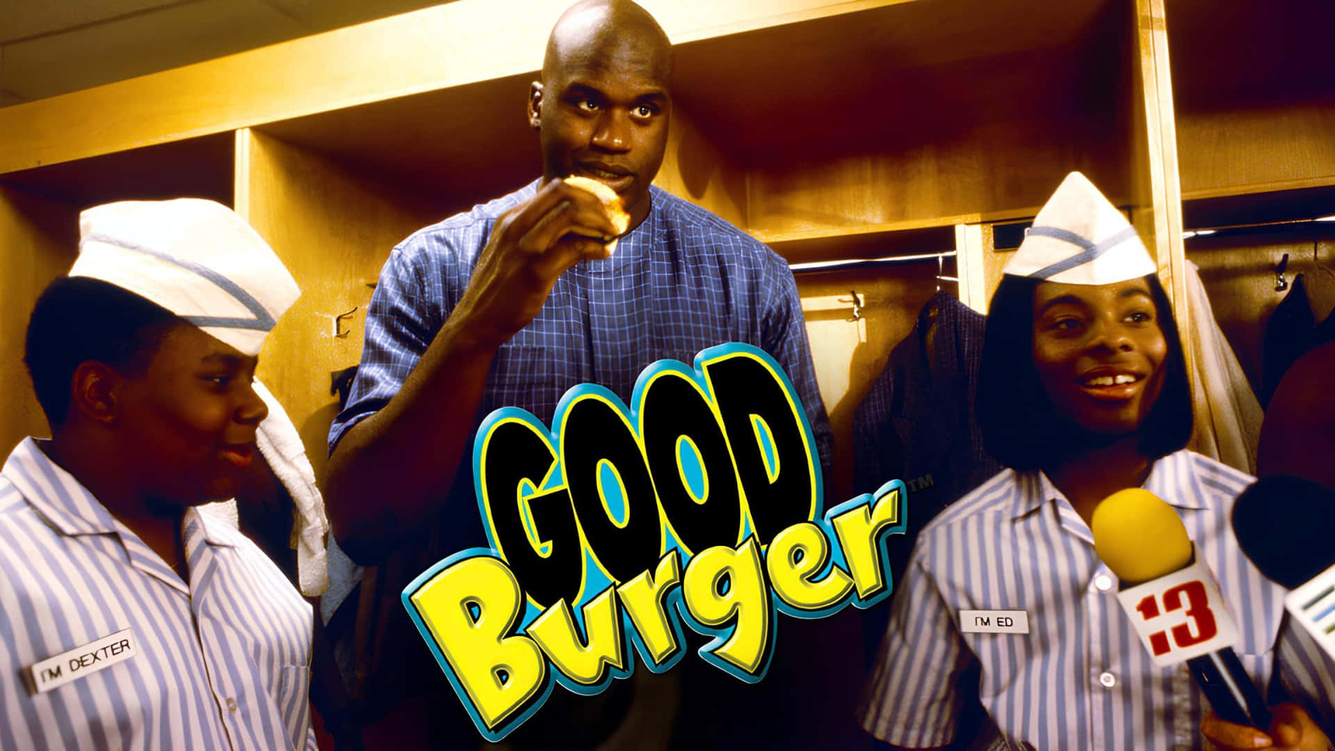  壁紙 — Shaquille O'Neal 在更衣室裡吃漢堡，旁邊有兩位戴著紙帽、穿著條紋制服、面帶微笑的工作人員。