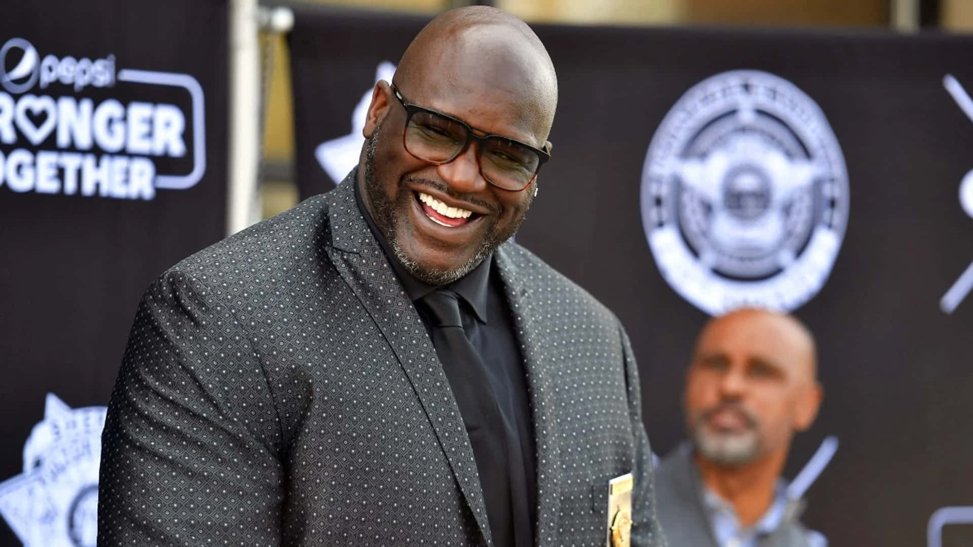  壁紙 — Shaquille O'Neal 在Pepsi品牌活動中穿著深色圓點西裝，面帶微笑，神采飛揚。