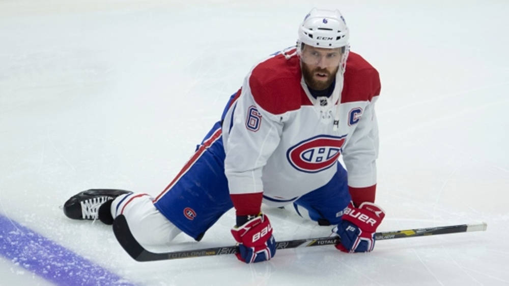 Shea Weber 跪地穿蒙特利爾加拿大人隊球衣 壁紙 — 一名身穿蒙特利爾加拿大人隊球衣的冰球運動員跪在冰上，專注地握著球桿。