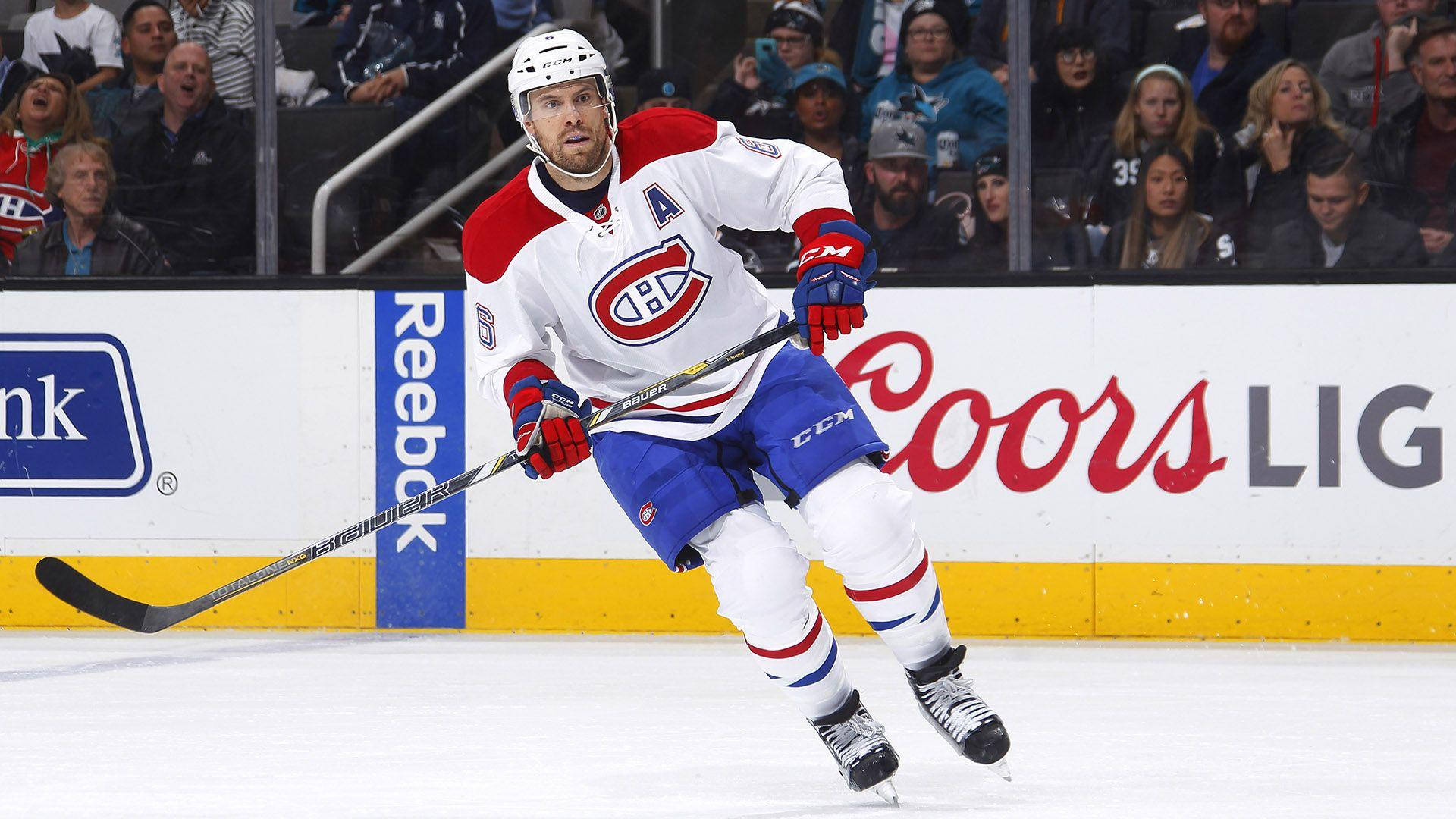 冰上之星Shea Weber，NHL頂尖球員 壁紙 — 穿著蒙特利爾加拿大人隊球衣的冰球運動員在冰上激烈滑行，人群在玻璃後觀看。