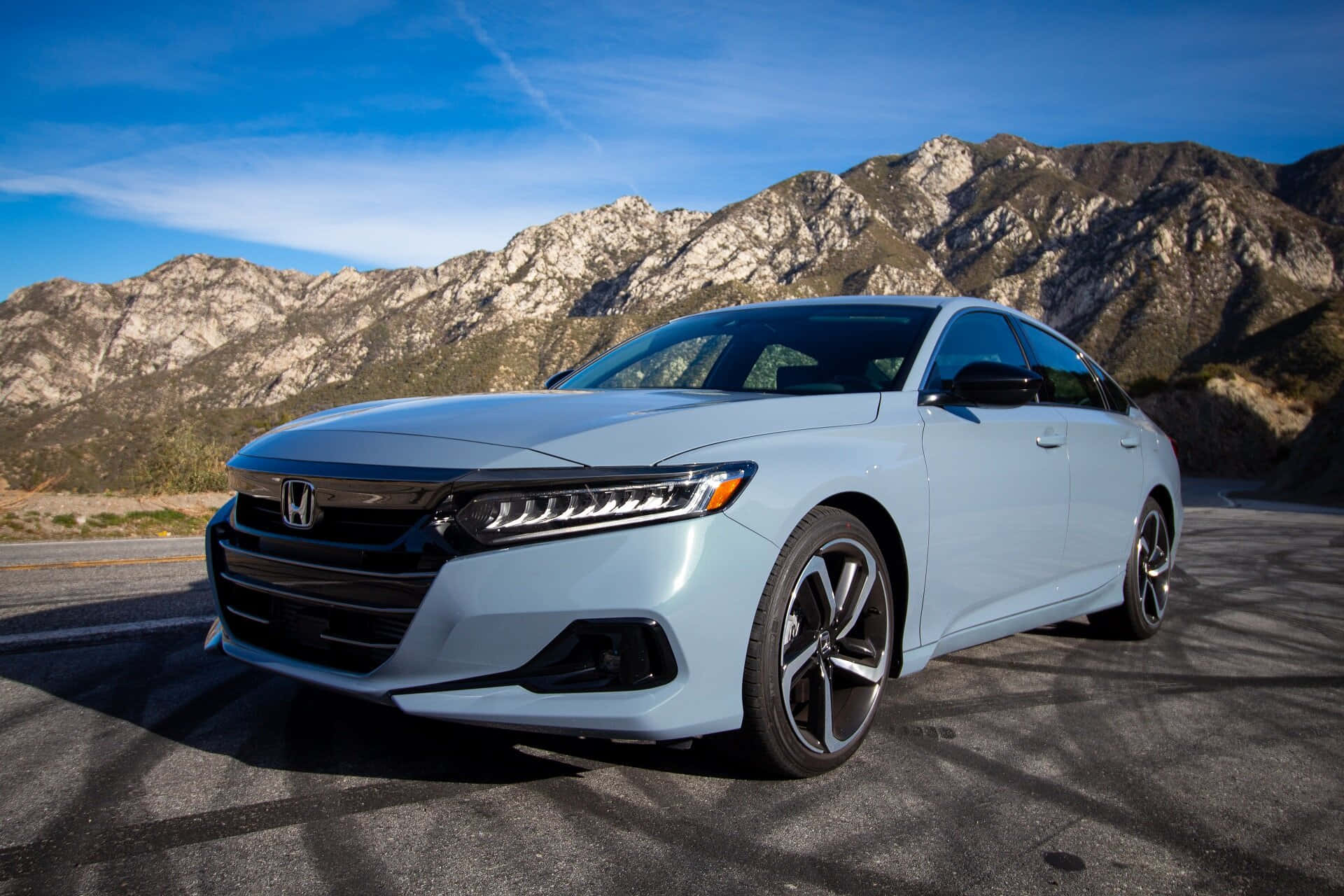Honda Accord 桌布 壁紙 — 一架時尚的淺藍色本田轎車停泊在山路上，背景是晴朗的藍天和崎嶇的山峰。