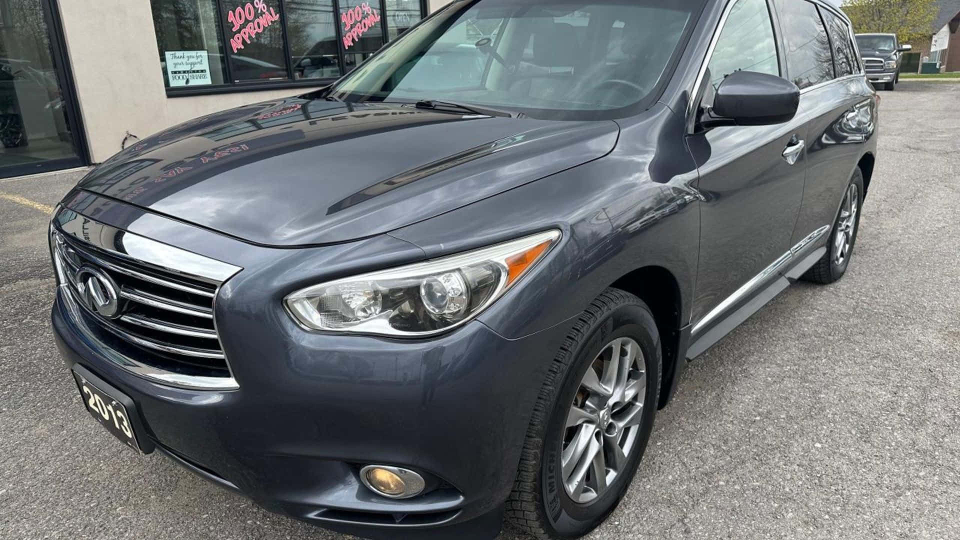 Infiniti Jx35 桌布 壁紙 — 一輛時尚的深灰色2013年Infiniti QX60 SUV停在經銷商前的瀝青路上，可見招牌。