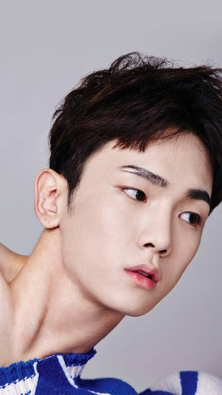 SHINee Key 特寫 壁紙 — 年輕黑髮男子特寫肖像，眼神銳利，身穿藍白針織毛衣，背景為中性灰色。