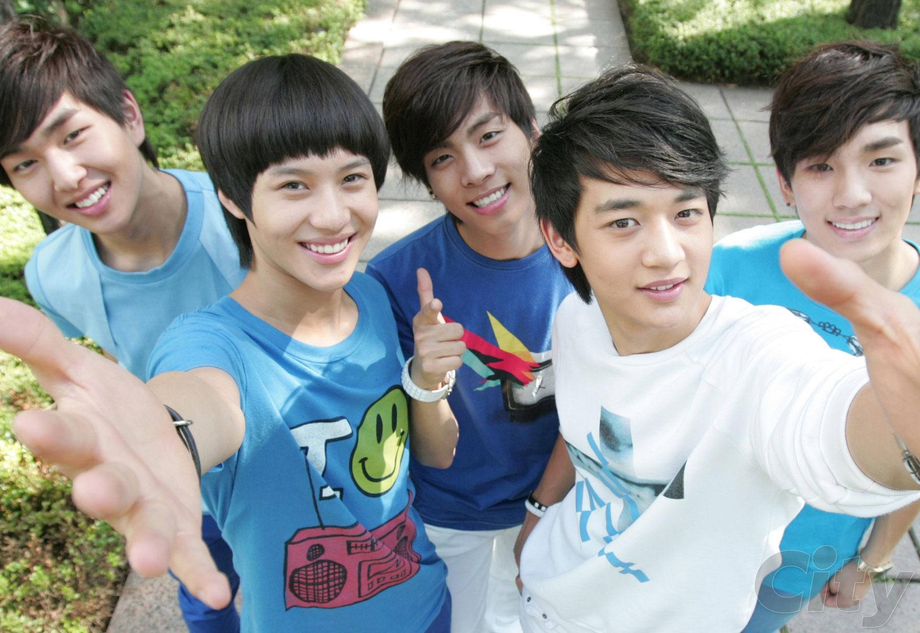 Shinee Pre Debut 壁紙 — 五個微笑的年輕男子穿著休閒T恤，在陽光明媚的日子裡開心地戶外自拍。