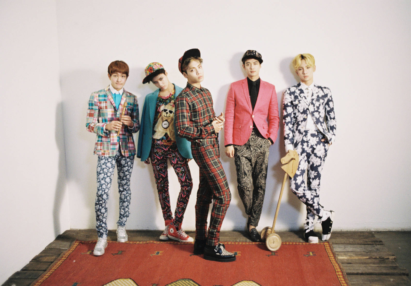 Shinee Quirky Clothes 壁紙 — 五位時尚年輕男士身穿大膽圖案西裝，在紅色地毯上自信地靠著純白牆壁擺姿勢。