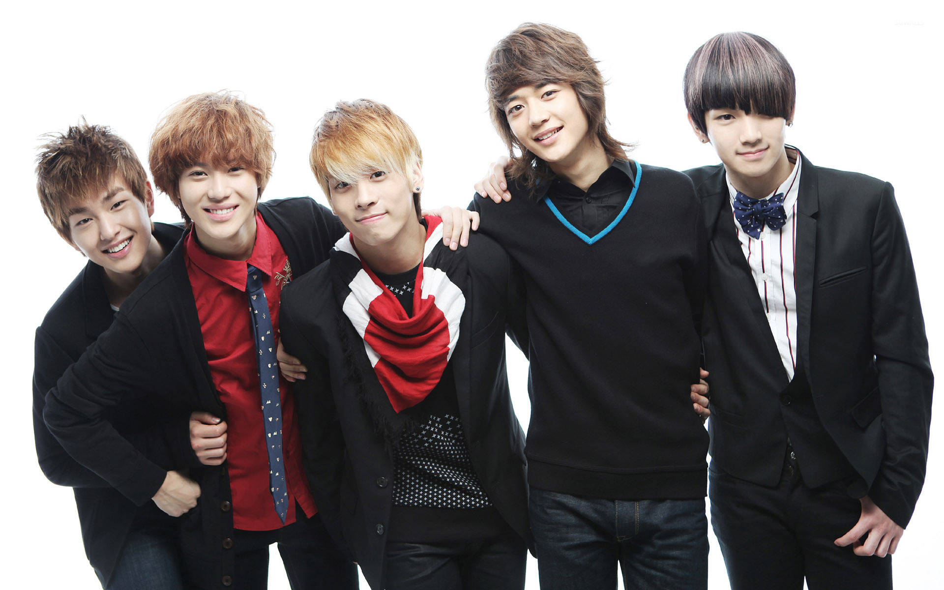 SHINee《Ring Ding Dong》造型照 壁紙 — 五位時尚年輕男子身穿黑色外套與彩色點綴，在純白背景前緊密擺姿勢，展現自信笑容。