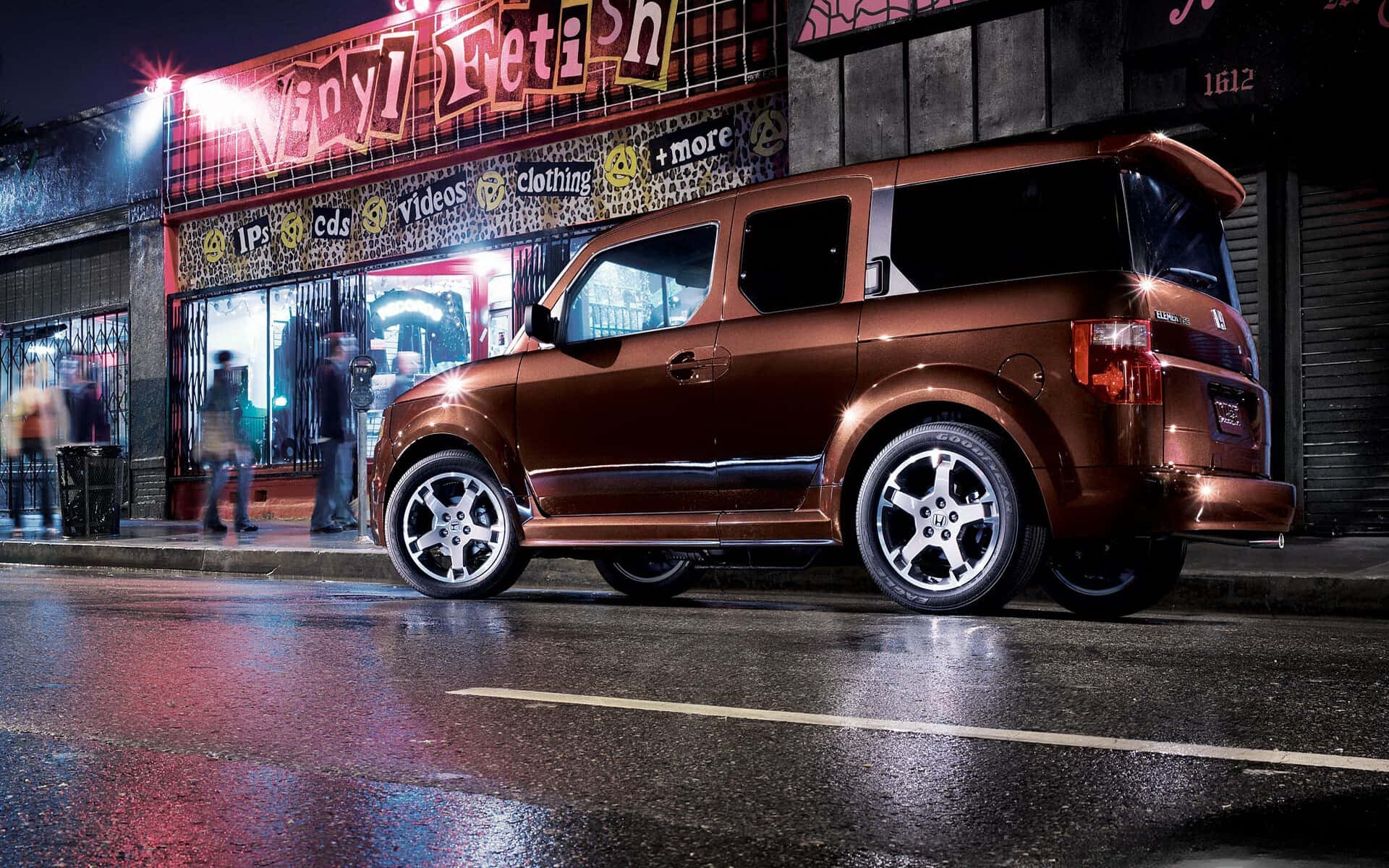 Honda Element 桌布 壁紙 — 一輛閃亮的青銅色SUV在夜間停泊在濕漉漉的城市街道上，黑膠唱片店的霓虹燈下。