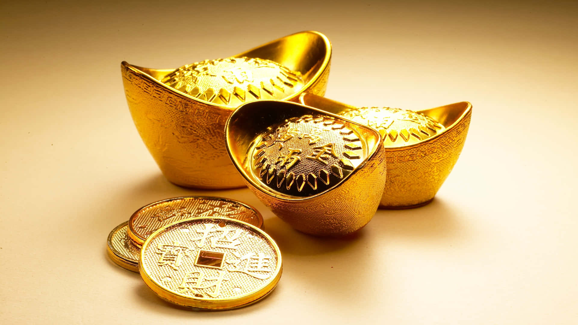 壁紙 — 閃亮的金條和金幣帶有中文字，在柔和的米色表面上於溫暖燈光下閃爍。