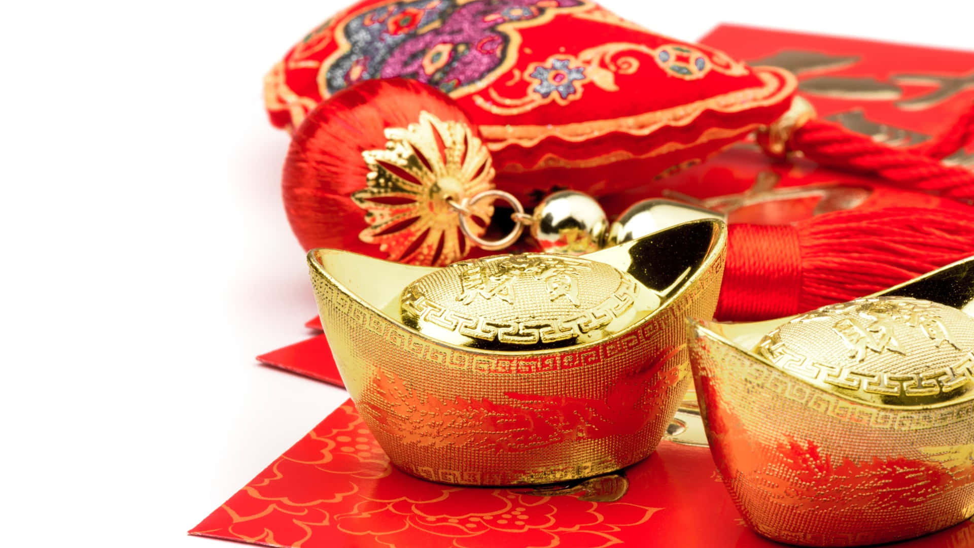  壁紙 — 閃亮的金條放在紅包上，旁邊有一個帶流蘇和花卉刺繡的裝飾性紅色小袋。