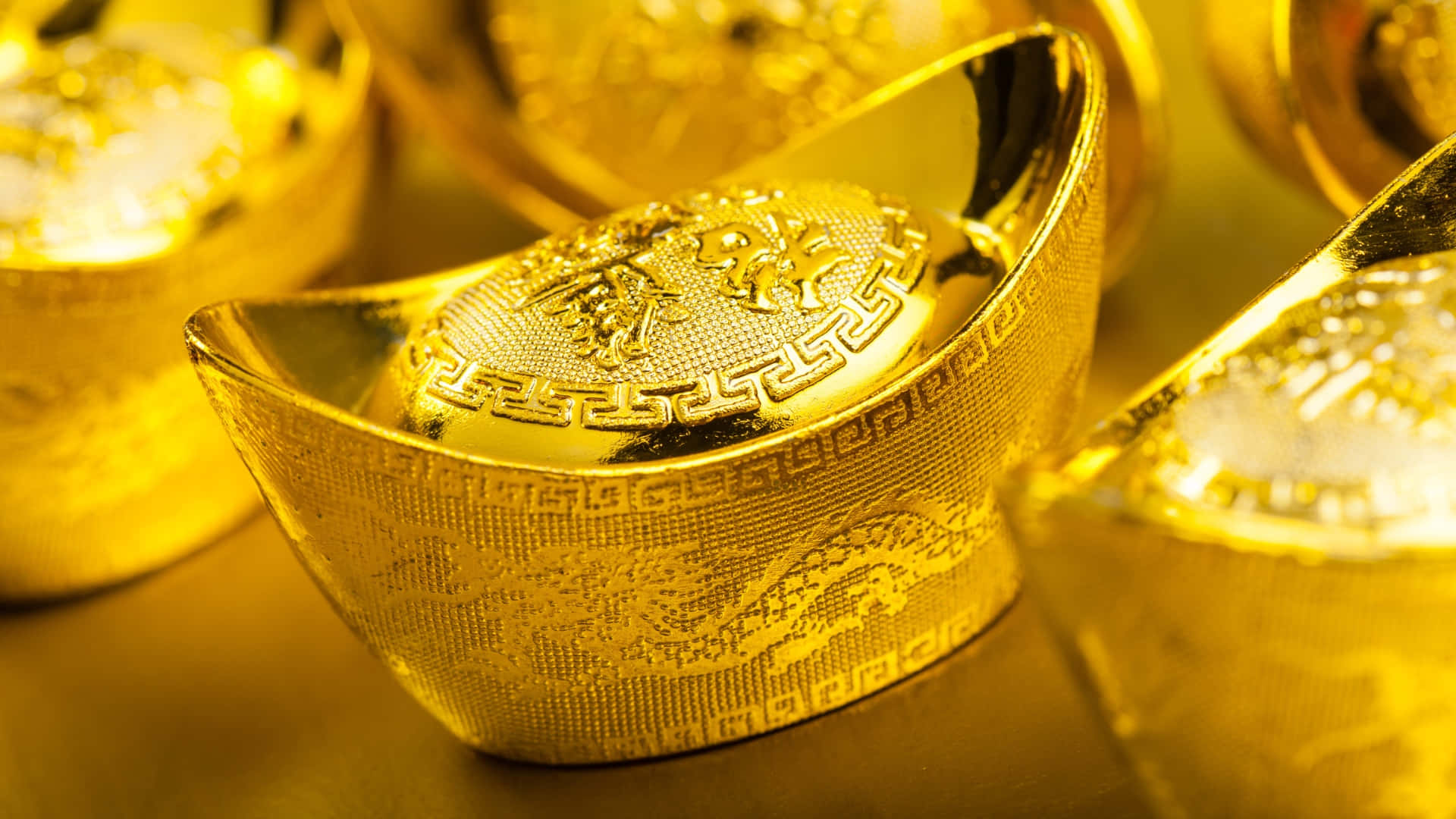  壁紙 — 閃閃發光的金條上刻有精緻的龍紋，在溫暖的燈光下閃耀，呈現奢華的特寫。