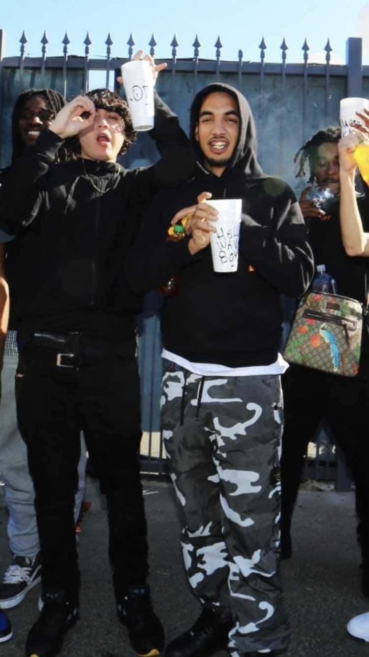一群年輕朋友在戶外圍欄附近舉杯暢飲。