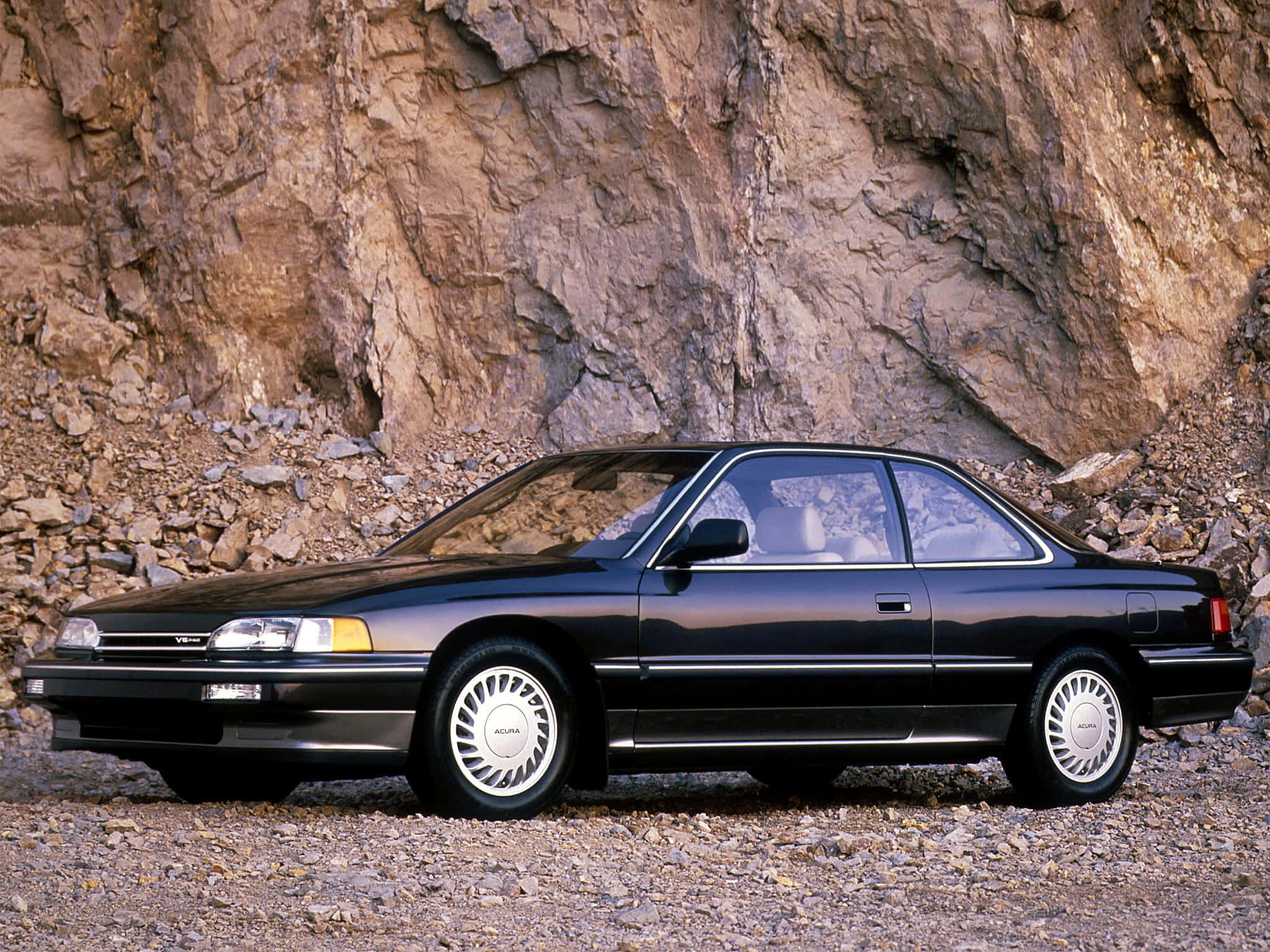 Acura Legend 桌布 壁紙 — 一架時尚黑色Acura Integra雙門跑車停泊在岩石地形上，背景是崎嶇的懸崖面。