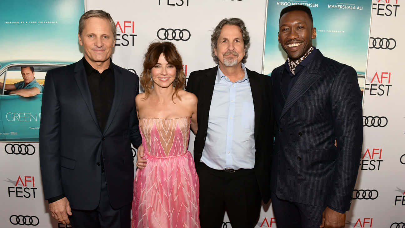 壁紙 — 四位微笑的名人在AFI FEST紅地毯活動中，在品牌背景前一起擺姿勢。