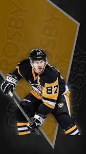 Sidney Crosby 冰球姿勢：握桿待發 壁紙 — 一名身穿黑金色球衣的曲棍球運動員，在幾何金黑背景前動態蹲下。