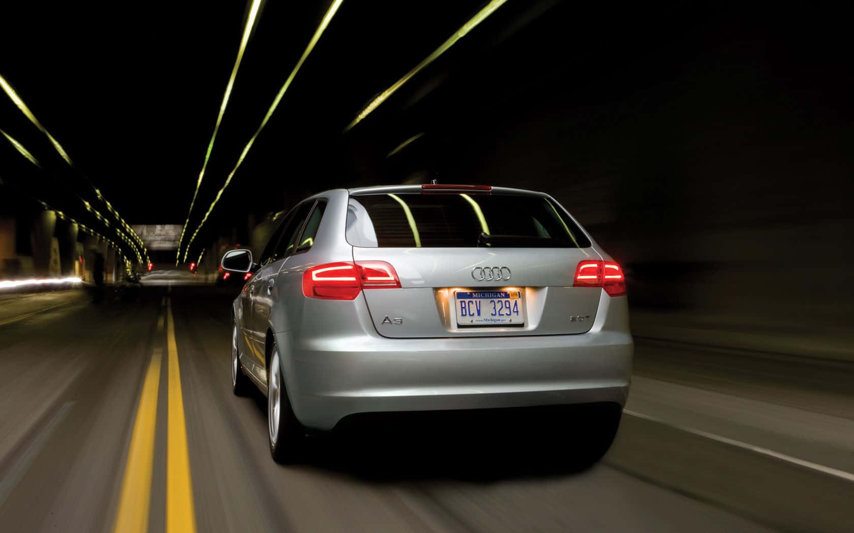 Audi A3 桌布 壁紙 — 一輛銀色奧迪A3旅行車在黑暗隧道中疾馳，帶有光條和模糊動態。