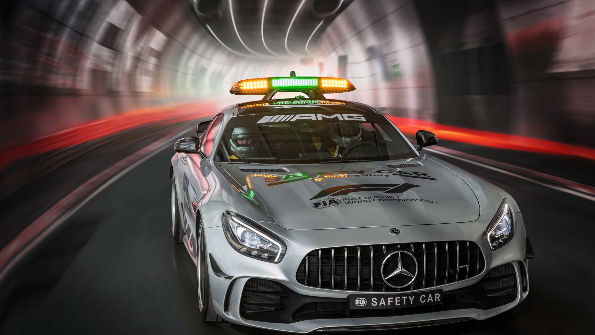 銀色梅賽德斯FIA安全車在隧道中高速行駛，帶有動態模糊效果。