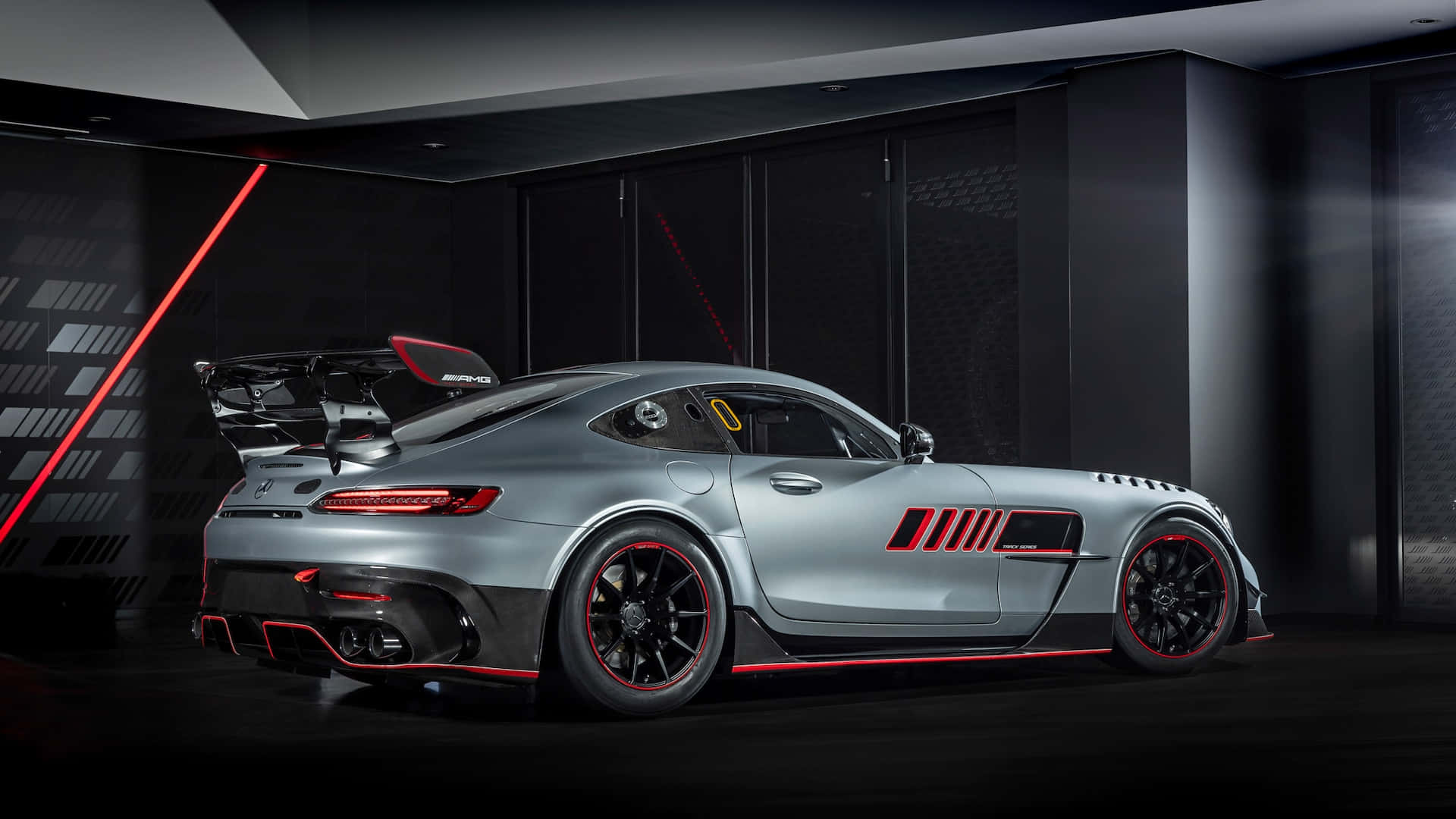 Mercedes Benz Amg Gt 桌布 壁紙 — 一輛時尚的銀色 Mercedes-AMG GT Black Series 帶有紅色點綴，在黑暗的高科技車庫中展示，配以戲劇性的紅色燈光。