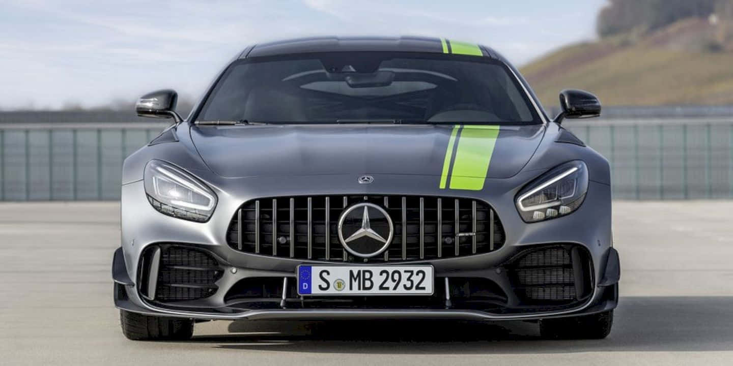  壁紙 — 一架型格銀色 Mercedes-AMG GT 帶有螢光綠色賽車條紋，在陰天下於賽道正面向前。