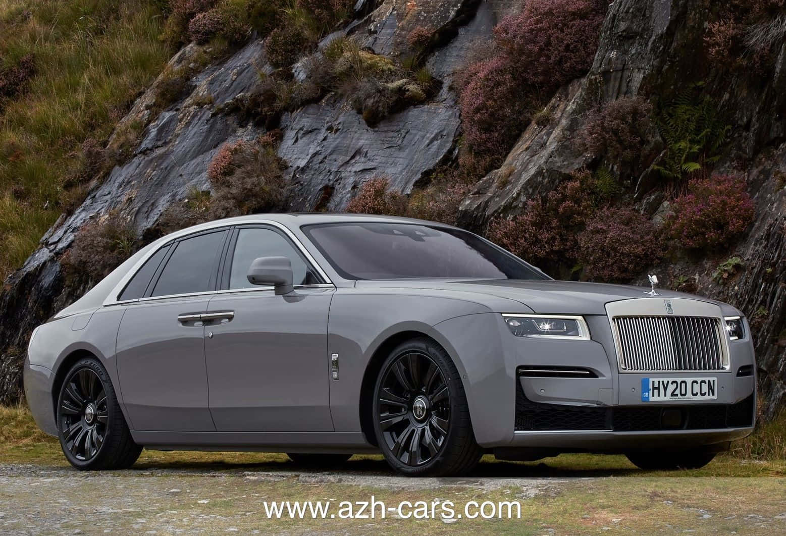Rolls Royce Camargue 桌布 壁紙 — 一架時尚的銀色勞斯萊斯 Ghost 停在碎石路上，背景是長滿苔蘚的崎嶇懸崖和紫色石楠花。