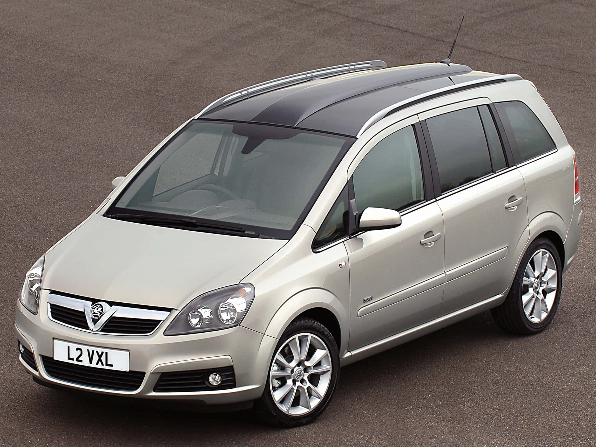 Opel Zafira 桌布 壁紙 — 一輛銀色 Vauxhall Zafira 旅行車停在瀝青路上，配有車頂行李架和有色車窗。