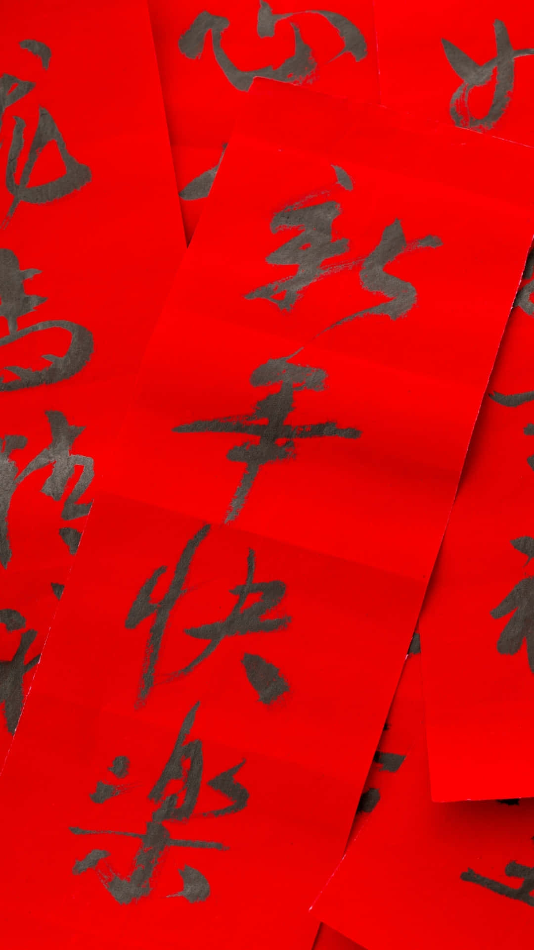  壁紙 — 鮮豔的紅紙上帶有粗體黑色中文書法，以節日特寫慶祝新年。