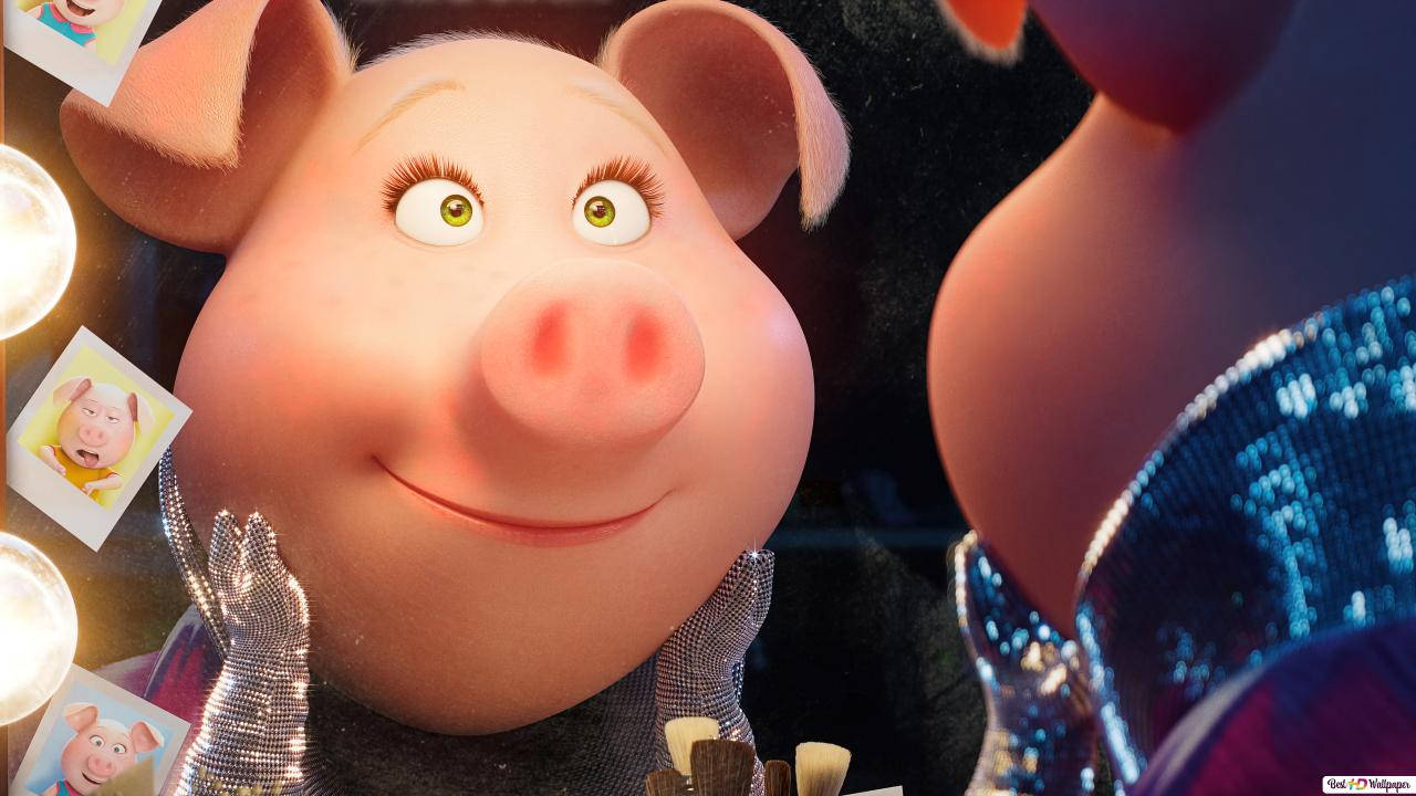 《Sing 2》動畫角色於絢麗舞台演出 壁紙 — 一隻快樂的動畫豬，擁有綠色眼睛和閃亮的銀色服裝，在舞台燈光下燦爛微笑。
