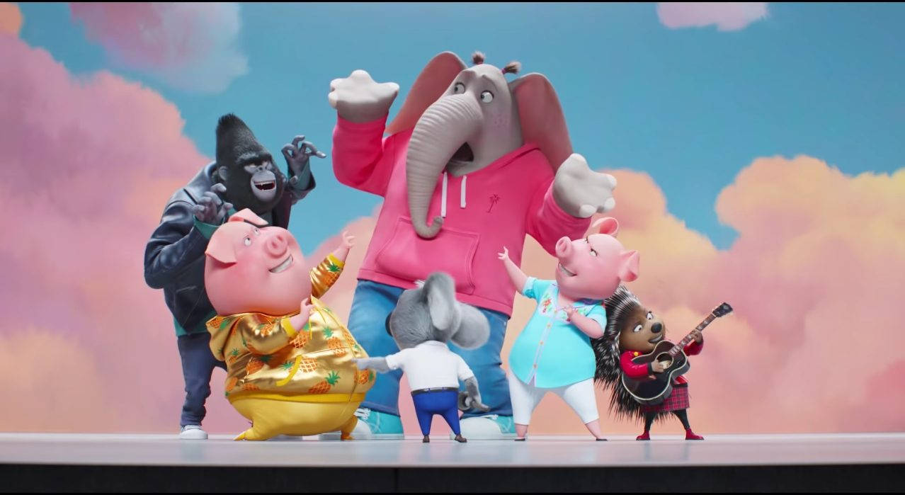 《Sing 2》粉紅雲朵舞台演出 壁紙 — 一群色彩繽紛的擬人化動物，穿著鮮豔的服裝，在粉彩天空背景下快樂地擺姿勢。