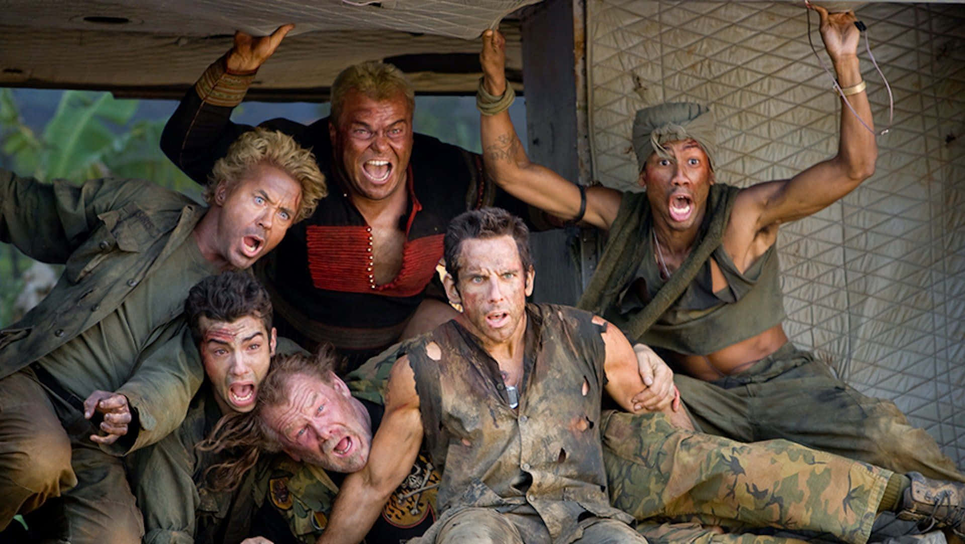  壁紙 — 六個穿著骯髒叢林裝備的男人在尖叫，驚恐地抓著一個正在倒塌的木結構。