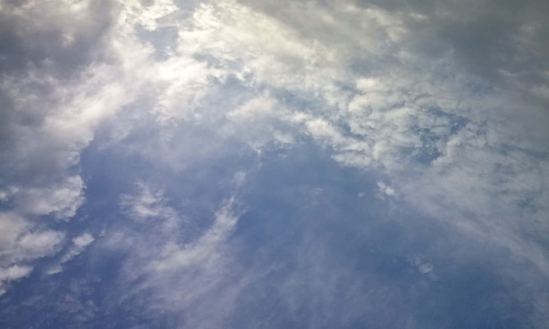SKY-13 壁紙 — 柔軟的白雲在寧靜的藍天上飄移，陽光透過縷縷雲層灑落。