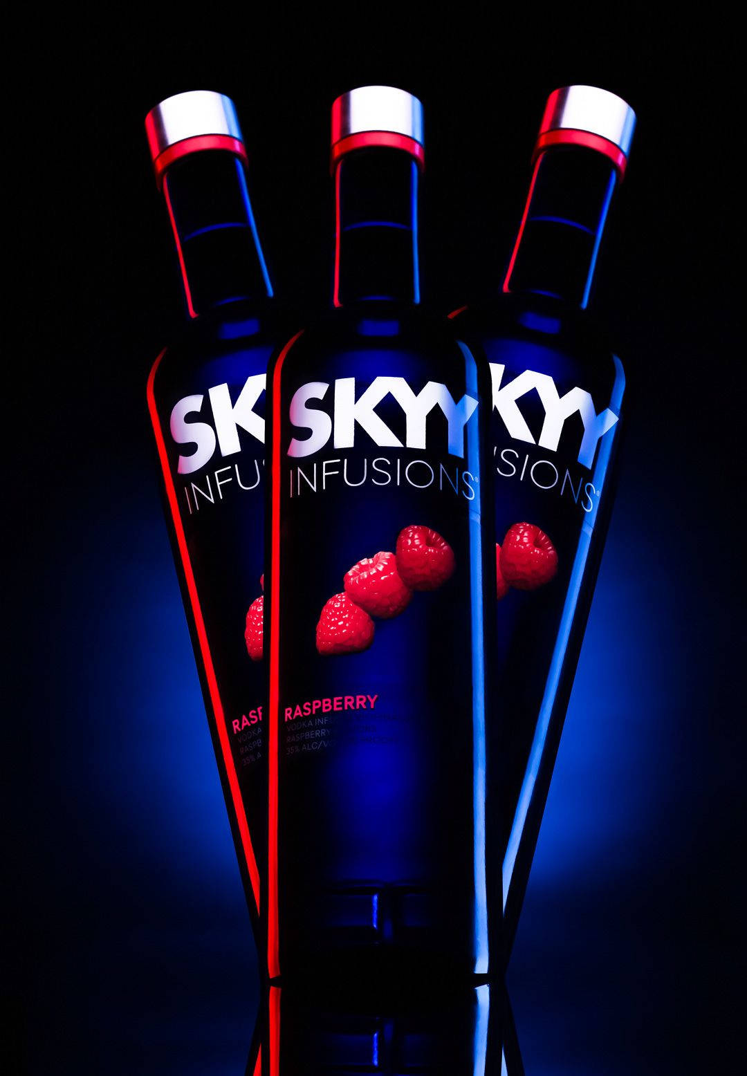 三支SKYY Raspberry伏特加酒瓶被紅色和藍色霓虹燈照亮。