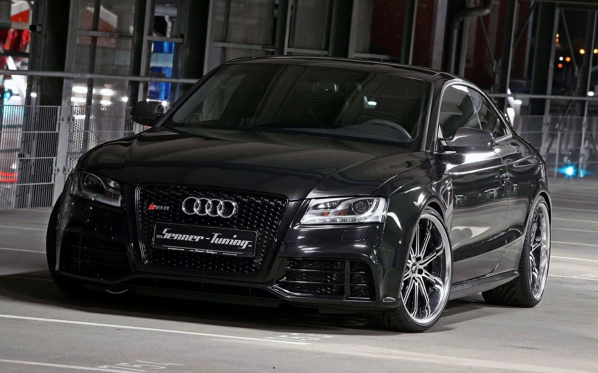 Audi S4 桌布 壁紙 — 一輛時尚的黑色奧迪RS5雙門轎跑車配備定制輪圈，在夜間濕潤的城市街道上，於城市燈光下閃閃發光。