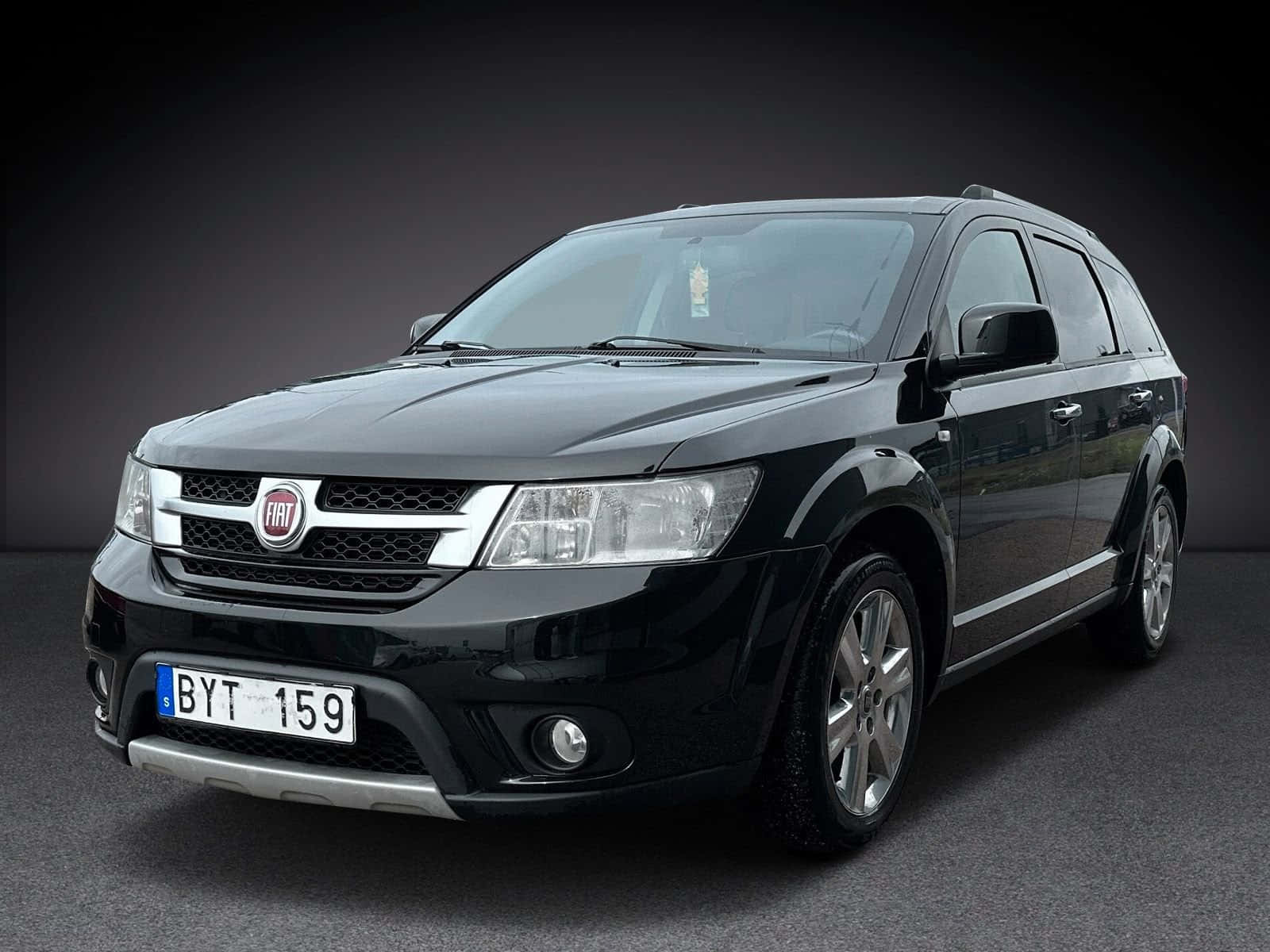  壁紙 — 一輛時尚的黑色Fiat SUV，帶有鍍鉻裝飾和銀色輪圈，在深色工作室背景下展示。