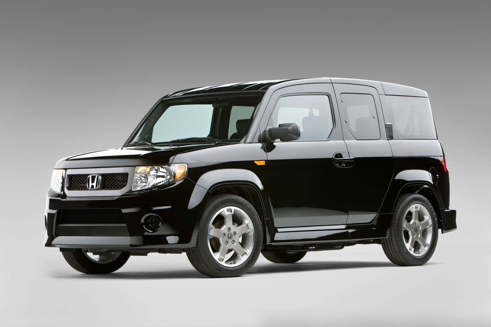 Honda Element 桌布 壁紙 — 一部時尚的黑色本田 Element SUV 在簡約的灰色工作室背景下展現其大膽的方正設計和銀色合金輪圈。